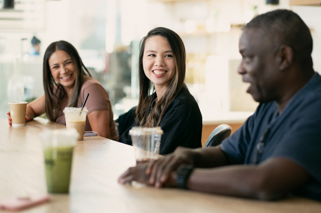Three coworkers having coffees together.