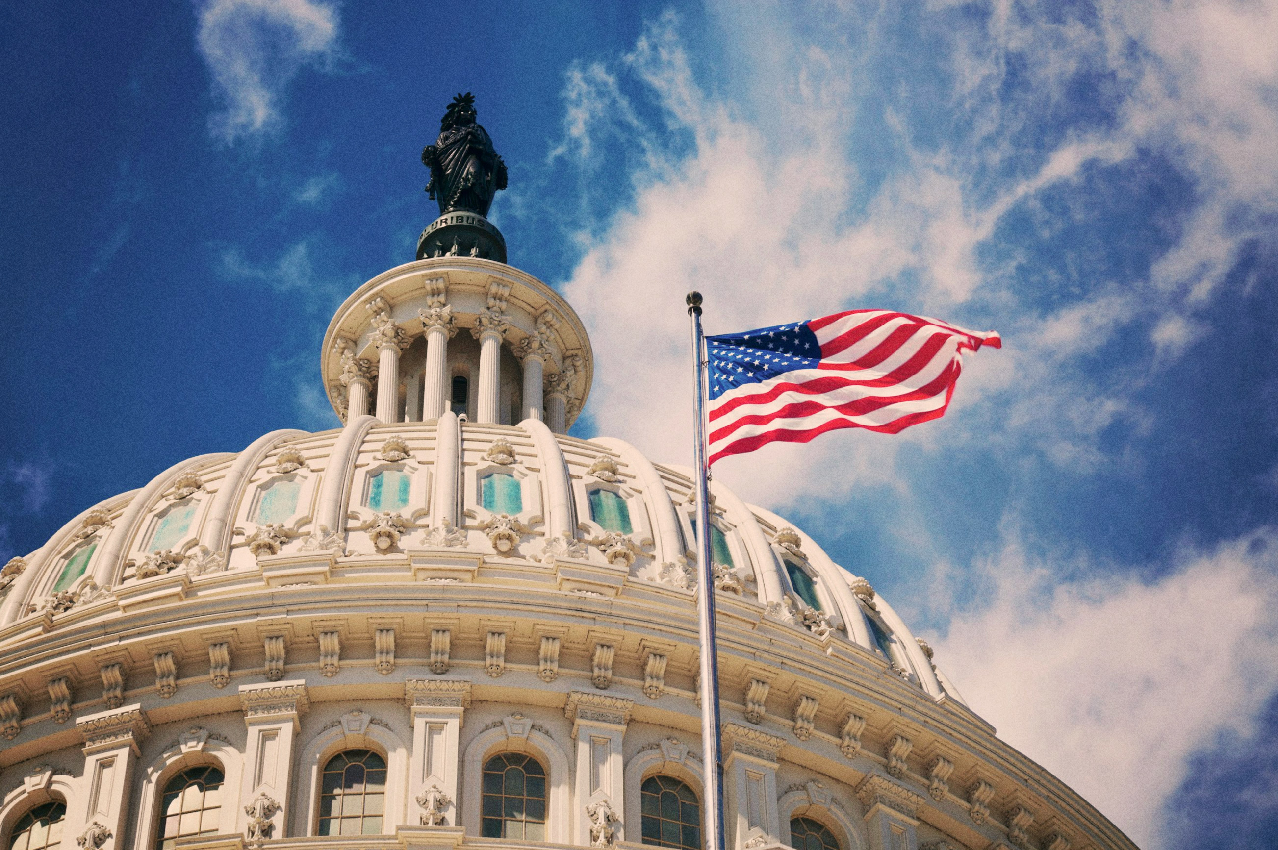 Exterior of government building with US flag flying in front
