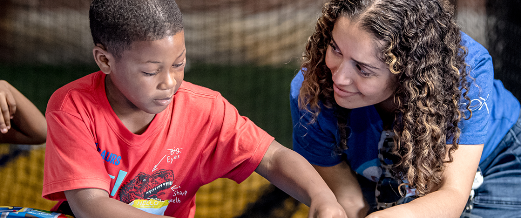 Cox volunteer working with young child