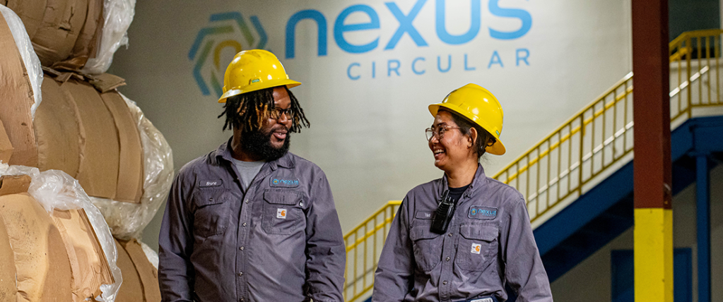 Two employees in hard hards standing chatting in Nexus circular