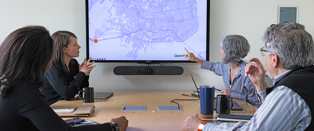 Group of employees around a conference table reviewing a presentation together