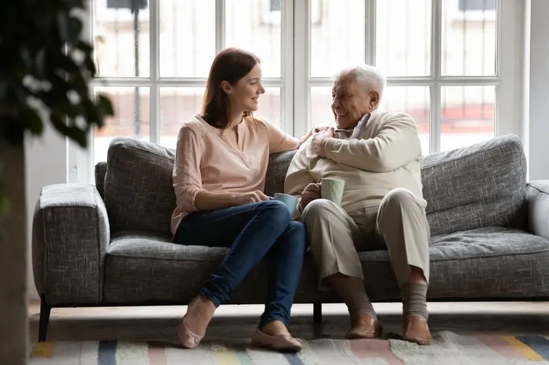 A young woman comforts an elderly man.